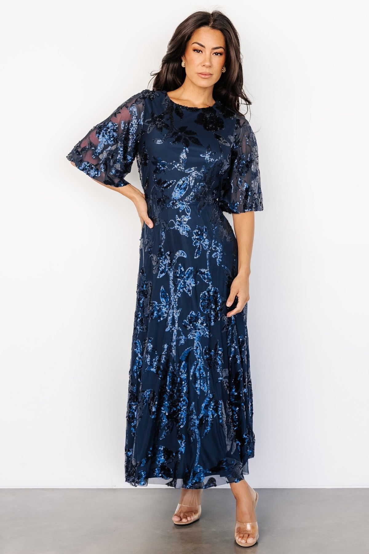 Detail of short tulle sleeve and raw hem edge with sequined embellishment, showing delicate sheer sleeve finish and texture.