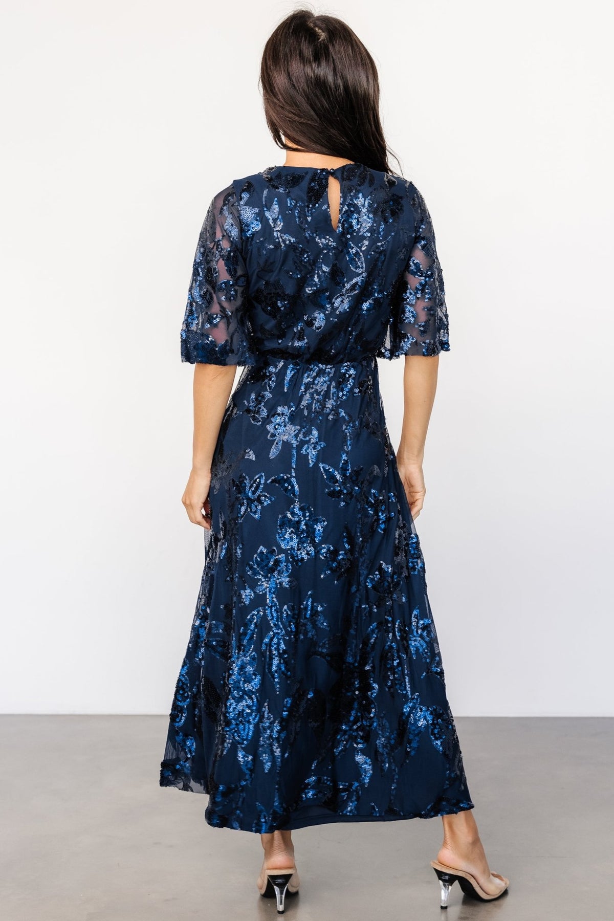 Full-length on-model image of the navy sequin maxi dress showing silhouette, skirt movement, and proportion for styling reference.