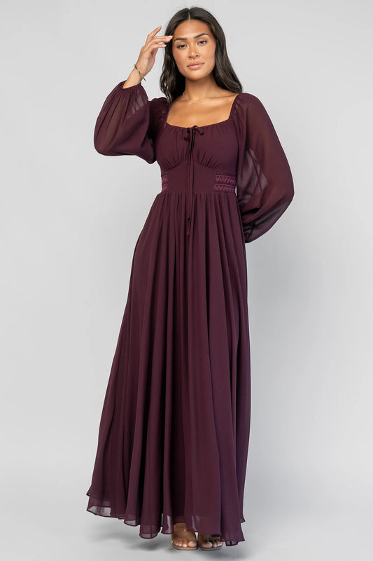 Maddalena Maxi Dress in Dark Plum with embroidered chevron detailing, a sweetheart neckline, and sheer sleeves.