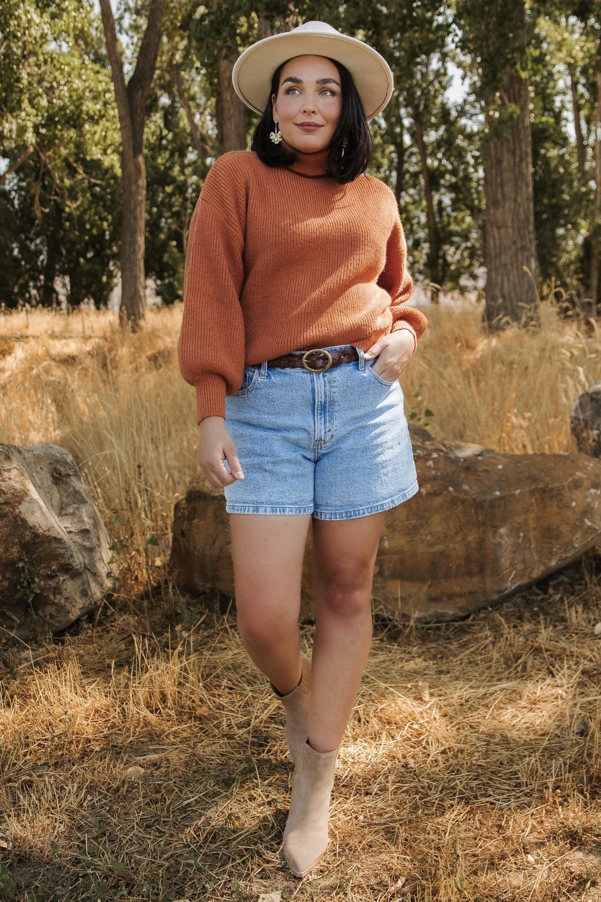 Close-up of sleeve and cuff on spice turtleneck sweater emphasizing bubble sleeve shape and ribbed cuff finish.