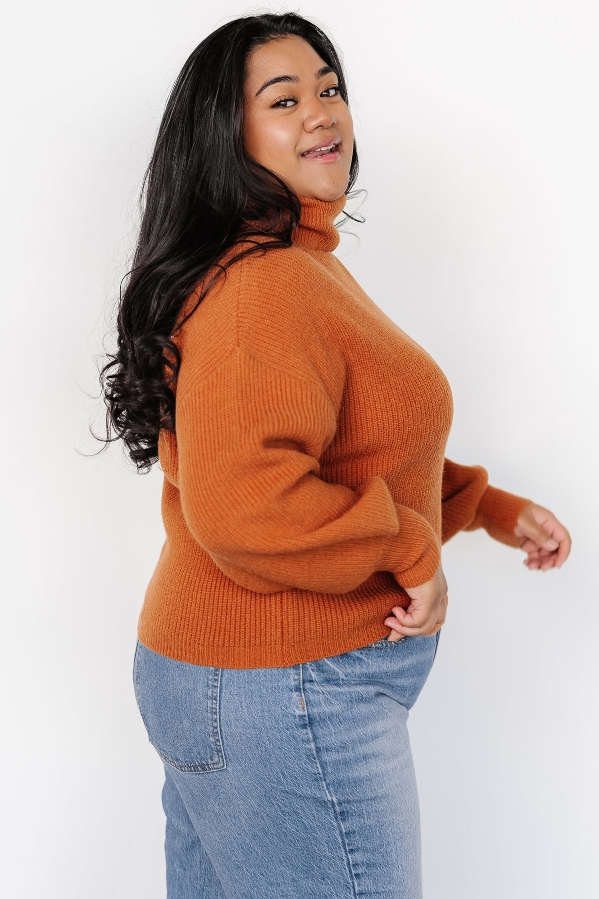 Back view of spice ribbed turtleneck sweater showing relaxed hem and consistent rib stitch across the garment.