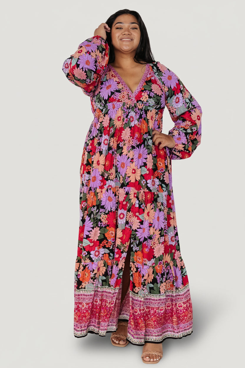 Model three-quarter view of Malena Maxi Dress in Black Multi, highlighting long sleeves with elastic cuffs and the flowing rayon fabric.