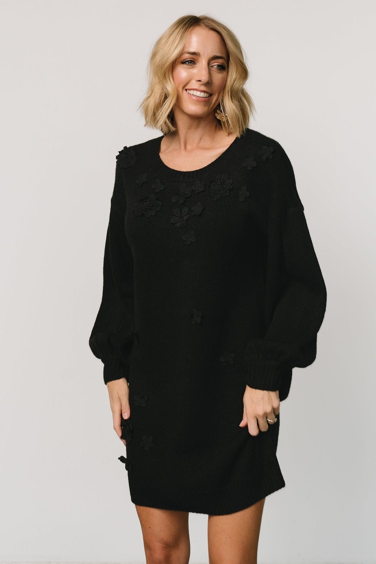 Back view of the Margaux sweater dress in black showing clean ribbed hemline and relaxed, slightly roomy back silhouette, with subtle knit texture.