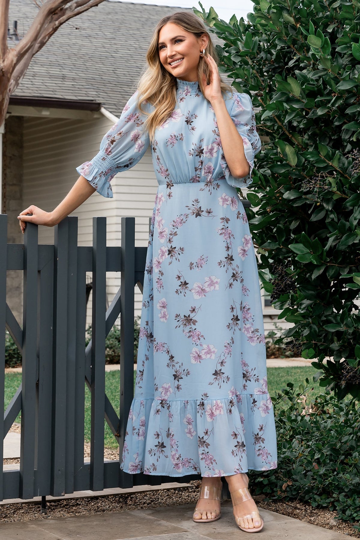 Close-up of smocked mock neckline and back keyhole with double-button closure on the sky-blue floral chiffon dress, showing texture and finish.
