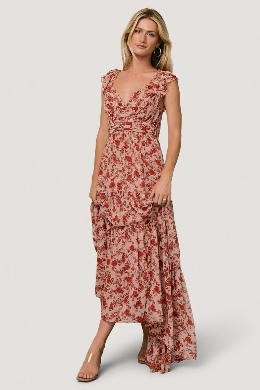 Full-length side view of Martina Maxi Dress in blush and red floral chiffon highlighting three-tiered skirt and soft ruffle trims.