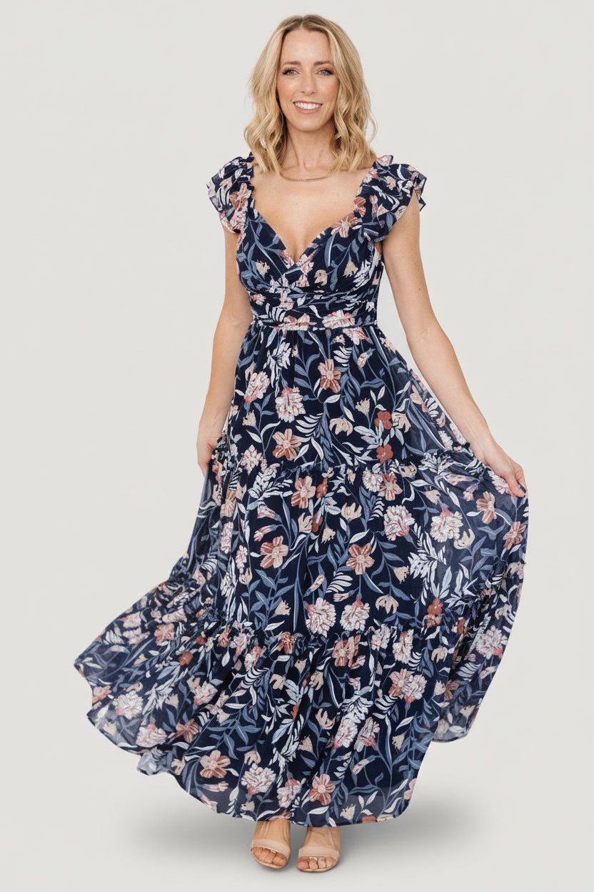 Front model view of Martina Maxi Dress in navy multi floral chiffon, showing V-neck, gathered bust, and flowing tiered skirt; model wearing size S.