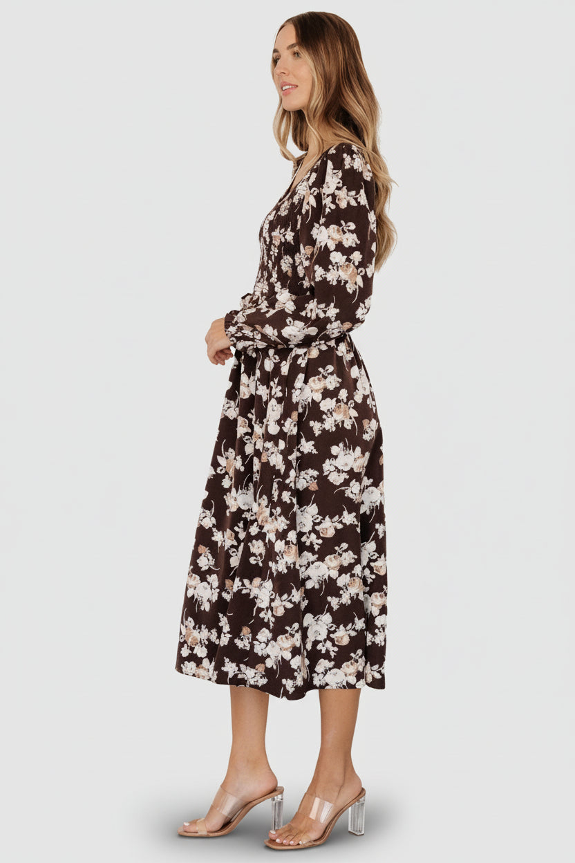 Back view of the brown floral midi dress showing gathered skirt, smocked bodice and midi hem length with gentle movement.