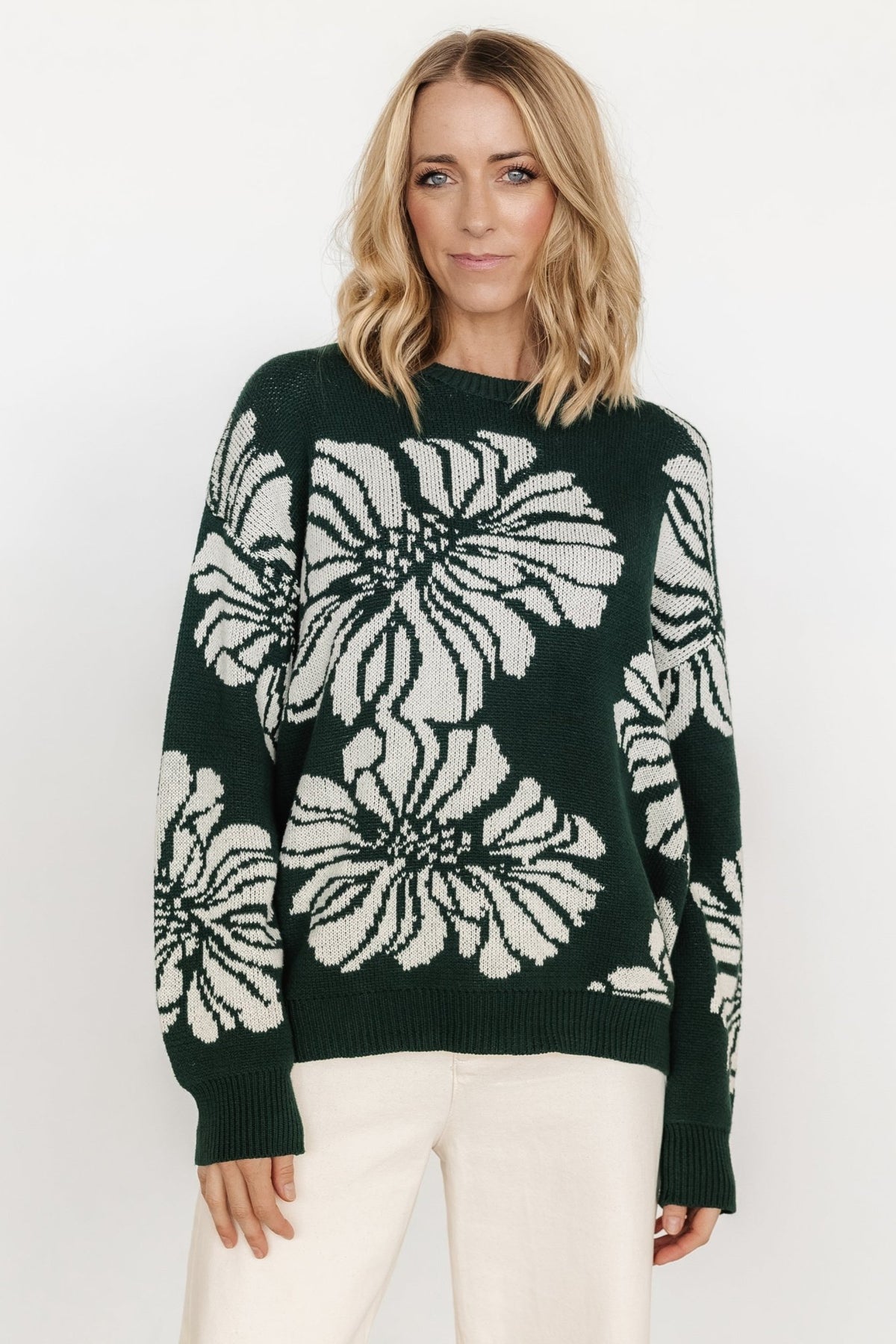 Detail shot of Maude sweater fabric and print, focusing on stitch definition, medium-weight feel and the contrast between green ground and off-white blooms.