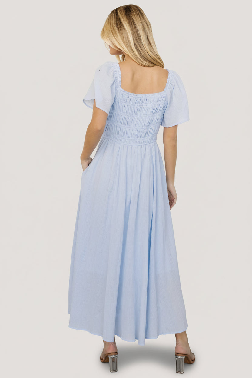 Side view of McKay maxi dress with front slit and lined skirt section, showing movement and length on model.