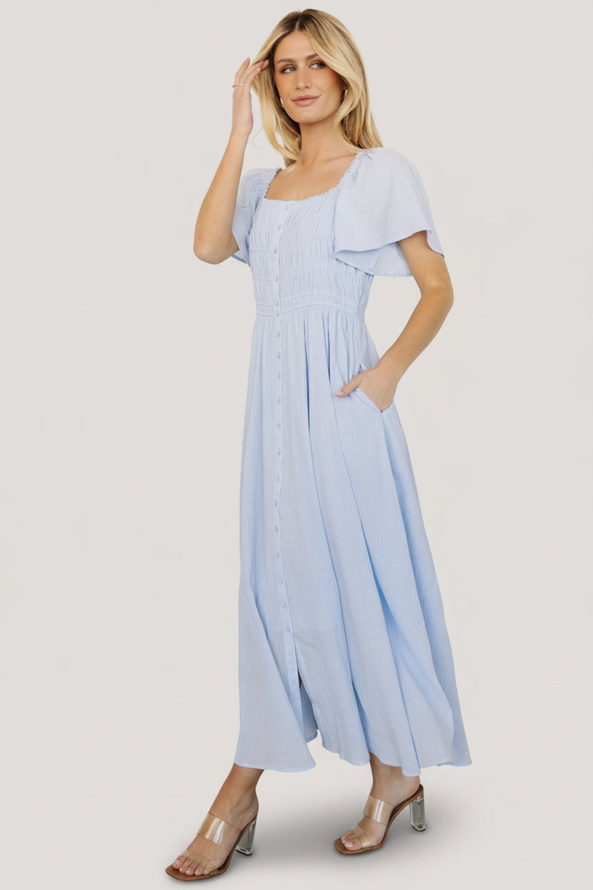 Model styling the McKay maxi dress for an event look with sandals, emphasizing its nursing-friendly design and pockets.