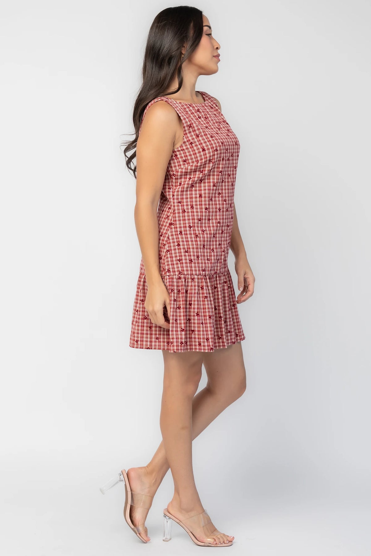 McQueen Short Dress in Red Gingham with bow details, sleeveless fitted bodice, drop waist, and ruffled short skirt.
