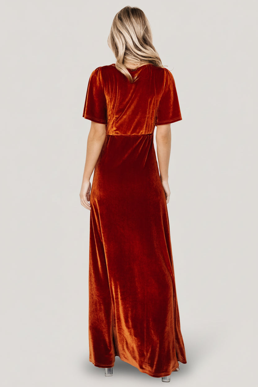 Detail view of the self-tie waist on rust velvet wrap dress, illustrating adjustable fit and secure wrap closure.
