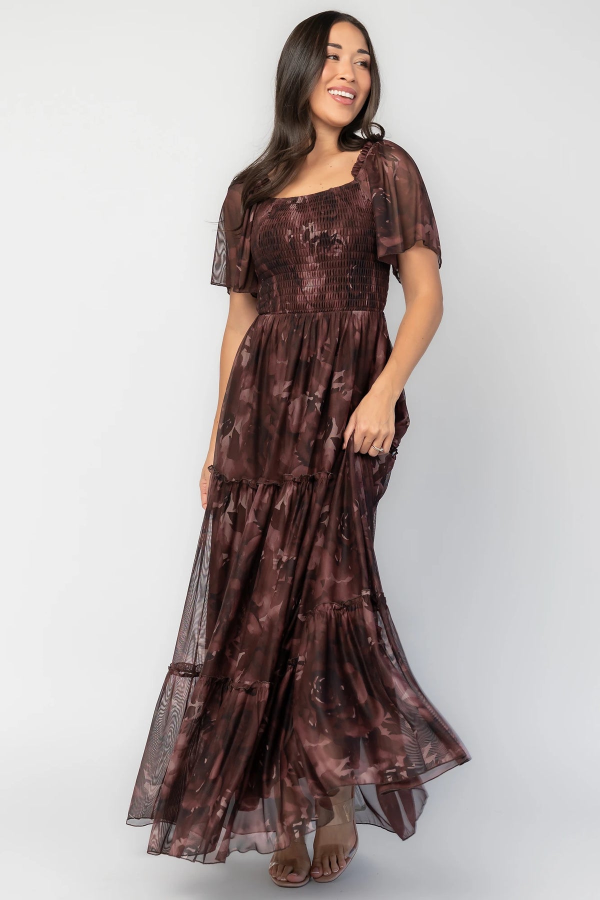 Meya Mesh Maxi Dress in Dark Mahogany Print with abstract florals, smocked bodice, flutter sleeves, and tiered skirt.
