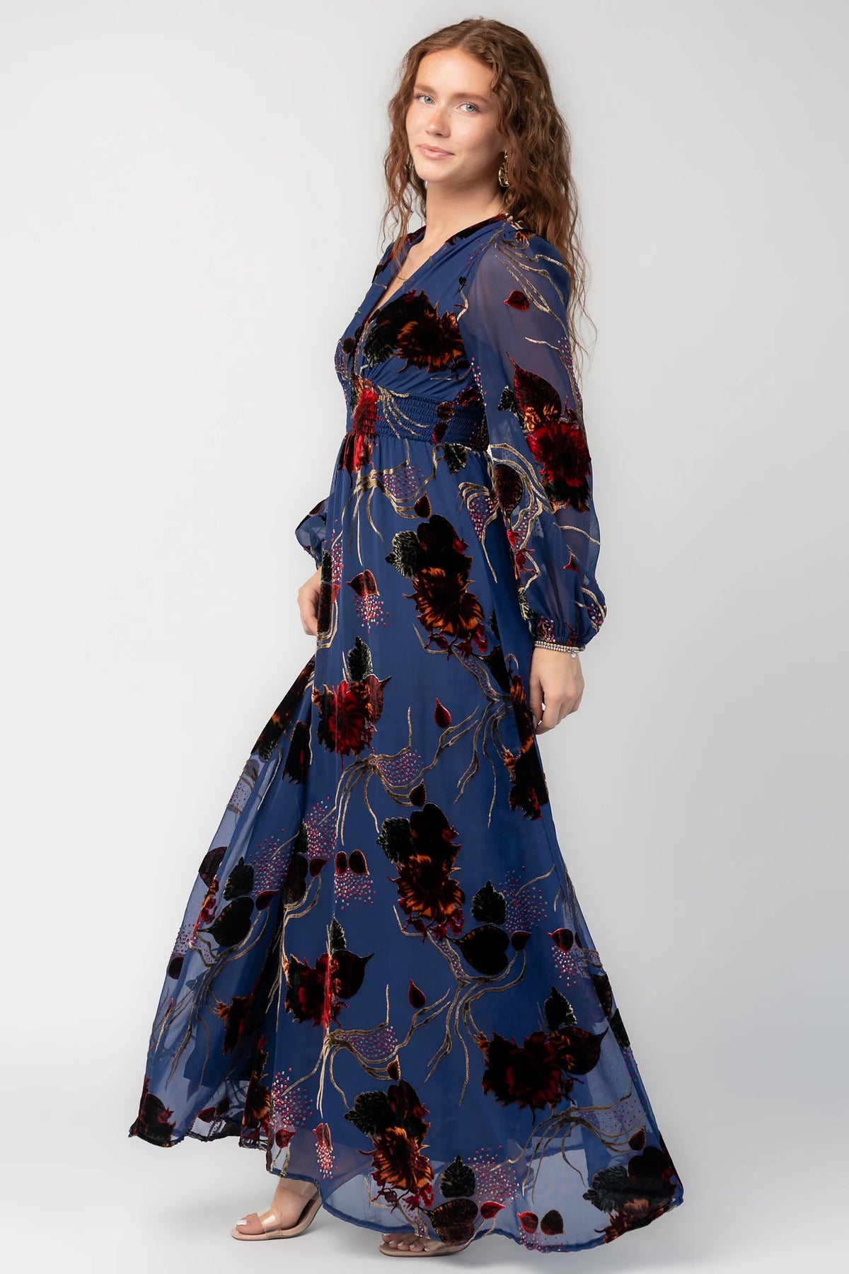 Mikla Maxi Dress in Blue Multi with burnout velvet, deep V-neck, long sleeves, smocked waist, and asymmetrical hem.
