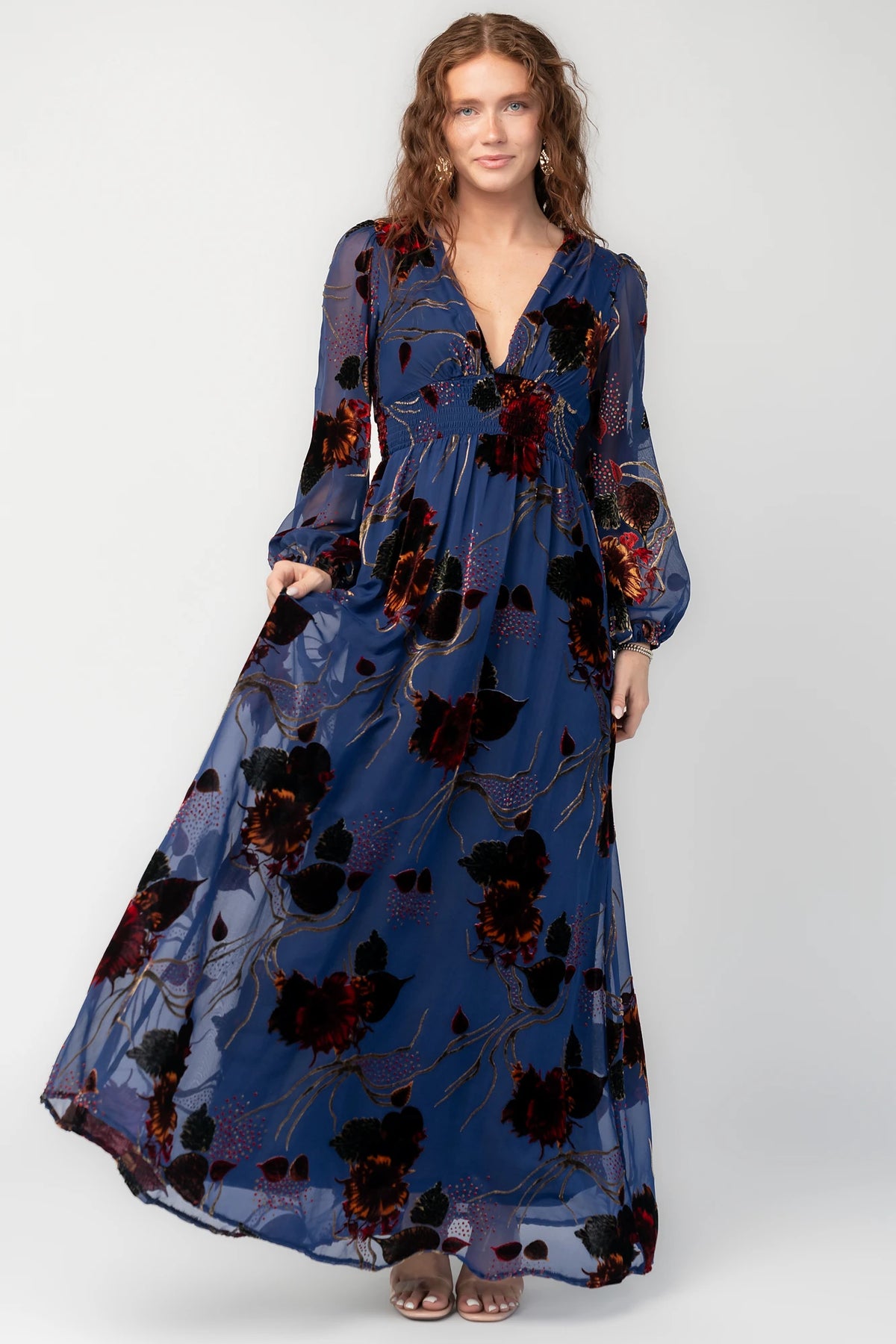 Mikla Maxi Dress in Blue Multi with burnout velvet, deep V-neck, long sleeves, smocked waist, and asymmetrical hem.