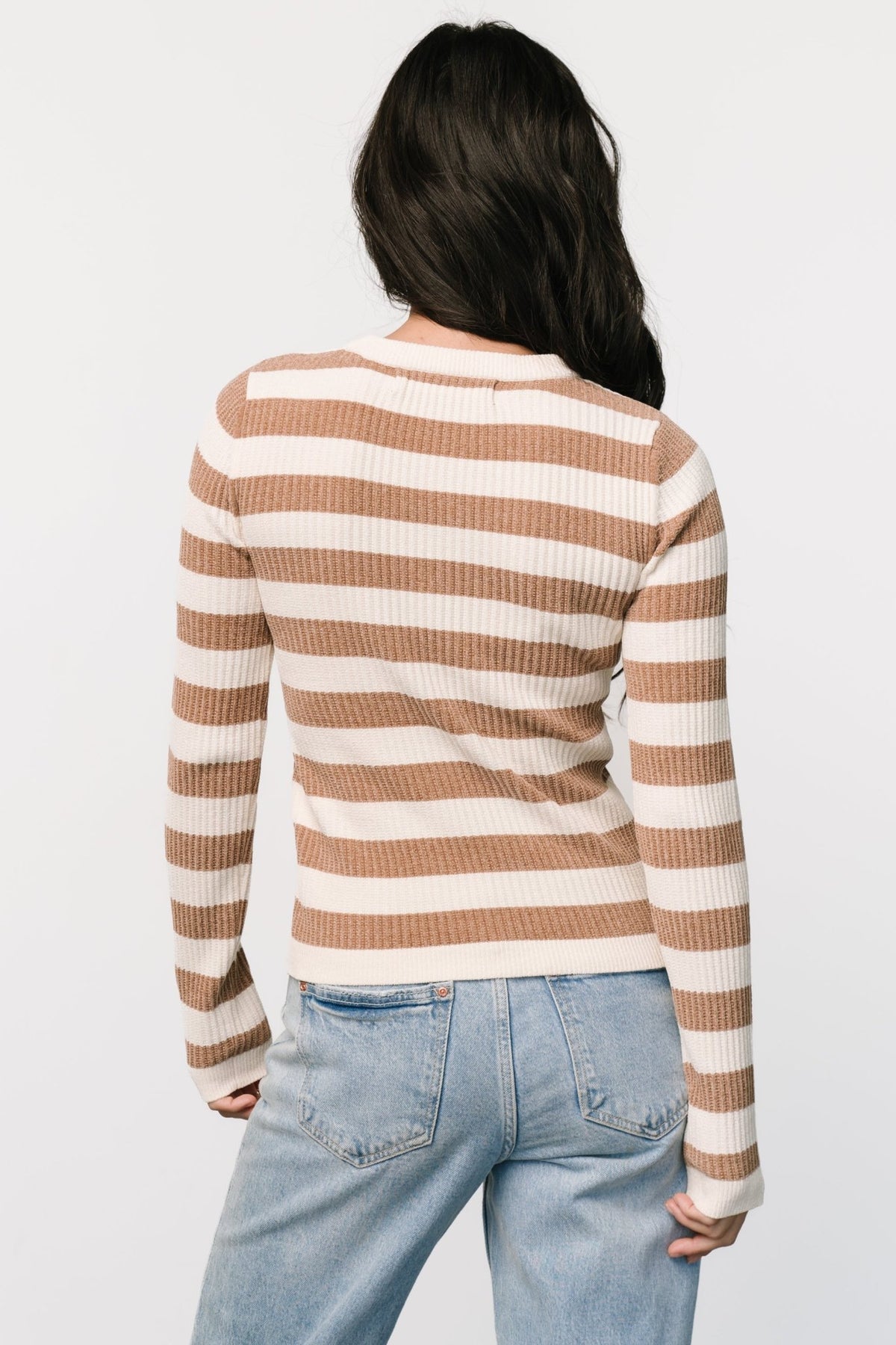 Close-up detail of camel and ivory velvet-knit fabric showing soft pile, knit texture, and stripe color contrast.