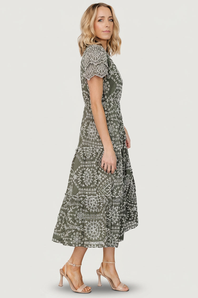 Close-up of embroidered eyelet detail and scalloped layered sleeve on the Mirabel Eyelet Midi Dress in olive and white.