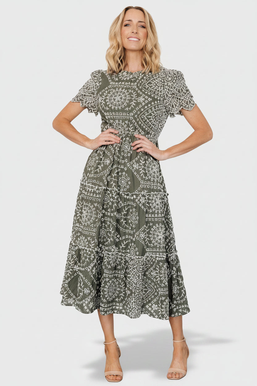 Front view of Mirabel Eyelet Midi Dress in olive and white showing embroidered eyelet, ruffle neckline, and tiered skirt.