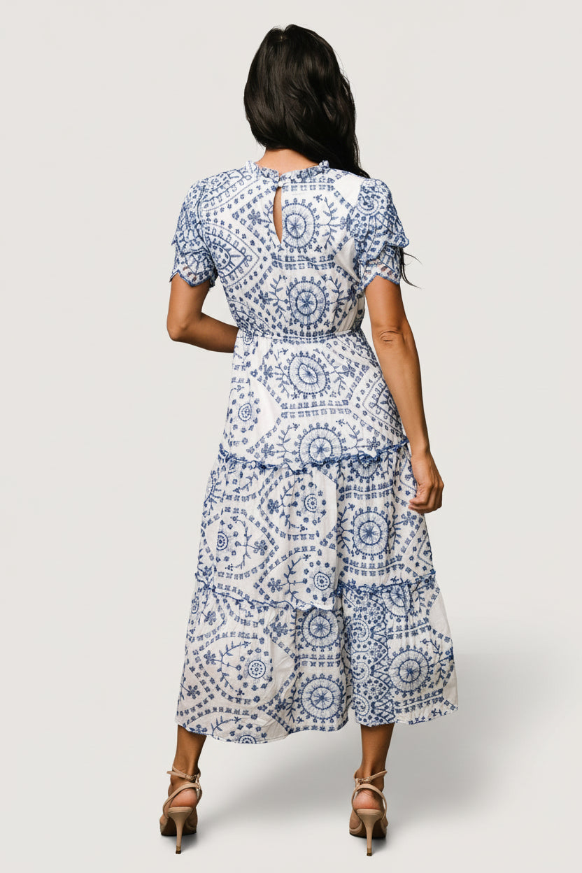 Side view highlighting the hidden side pocket and elastic waistband on the Mirabel midi dress with embroidered eyelet pattern.