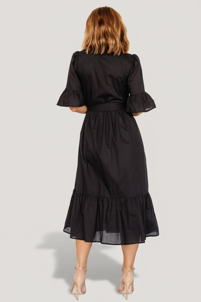 Model wearing the Mirielle black midi dress, showing fit through the shoulders and how the removable sash defines the waist.