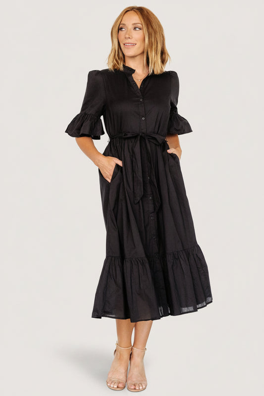 Front view of the Mirielle black midi dress showing ruffled collar, button-front closure, removable waist sash, and short ruffled sleeves.