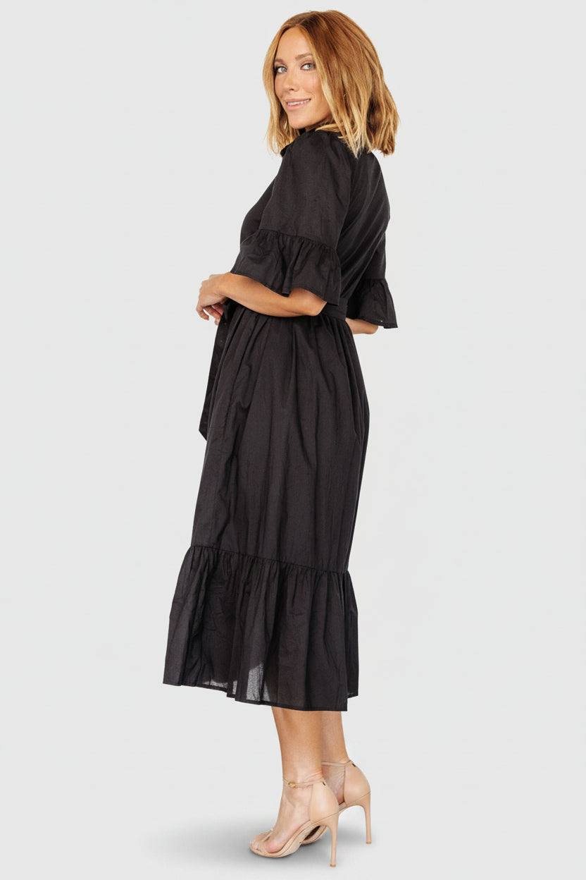Close-up of the Mirielle dress bodice with ruffled collar, functional buttons, and detachable self-tie waist sash detail.