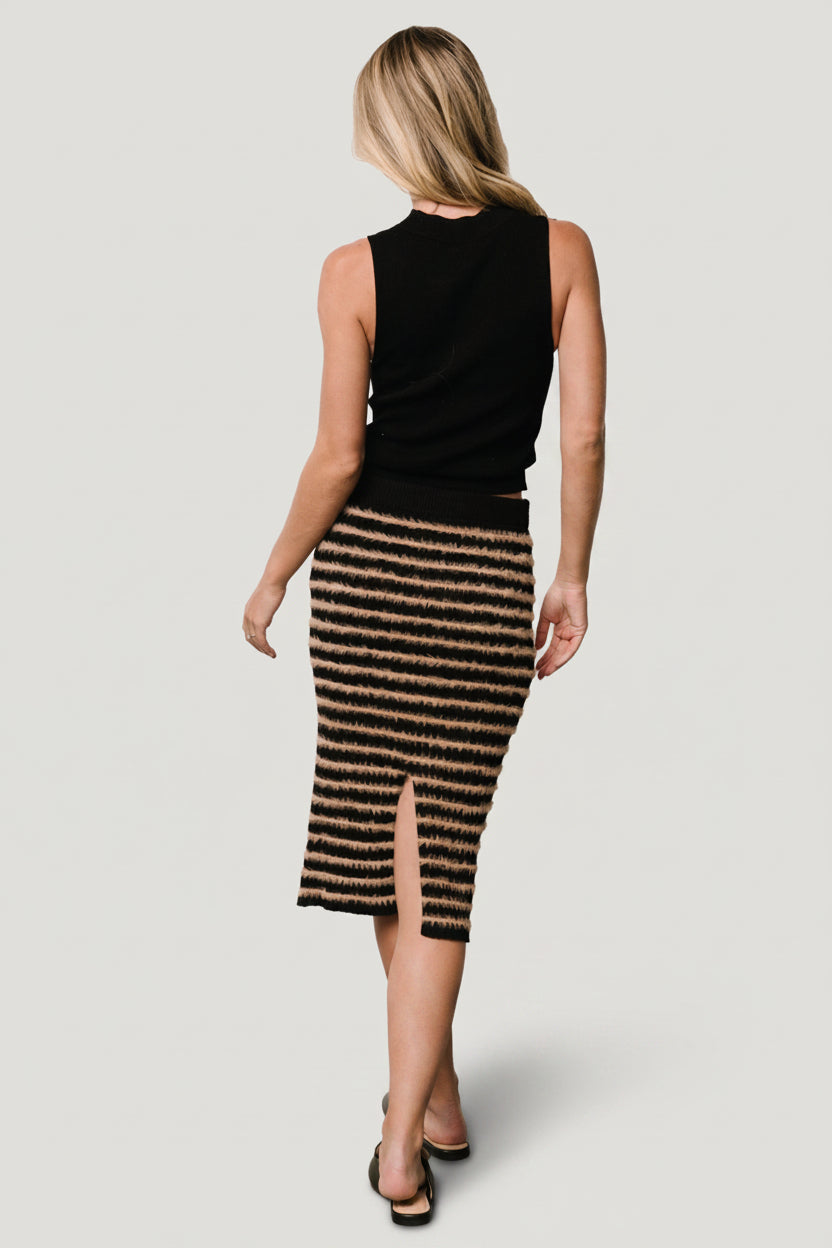 Back view of Mitzi skirt showing center slit with raw hem and ribbed finish, emphasizing movement and tailoring details.
