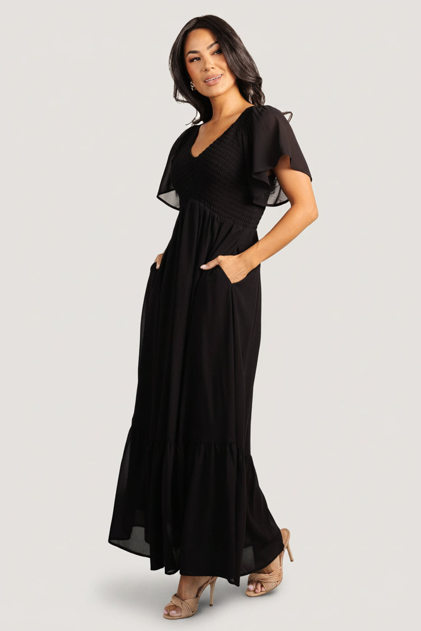 Close-up of smocked bodice and upturned V high waist on the Monica Smocked Dress, highlighting center-seamed detail and texture.