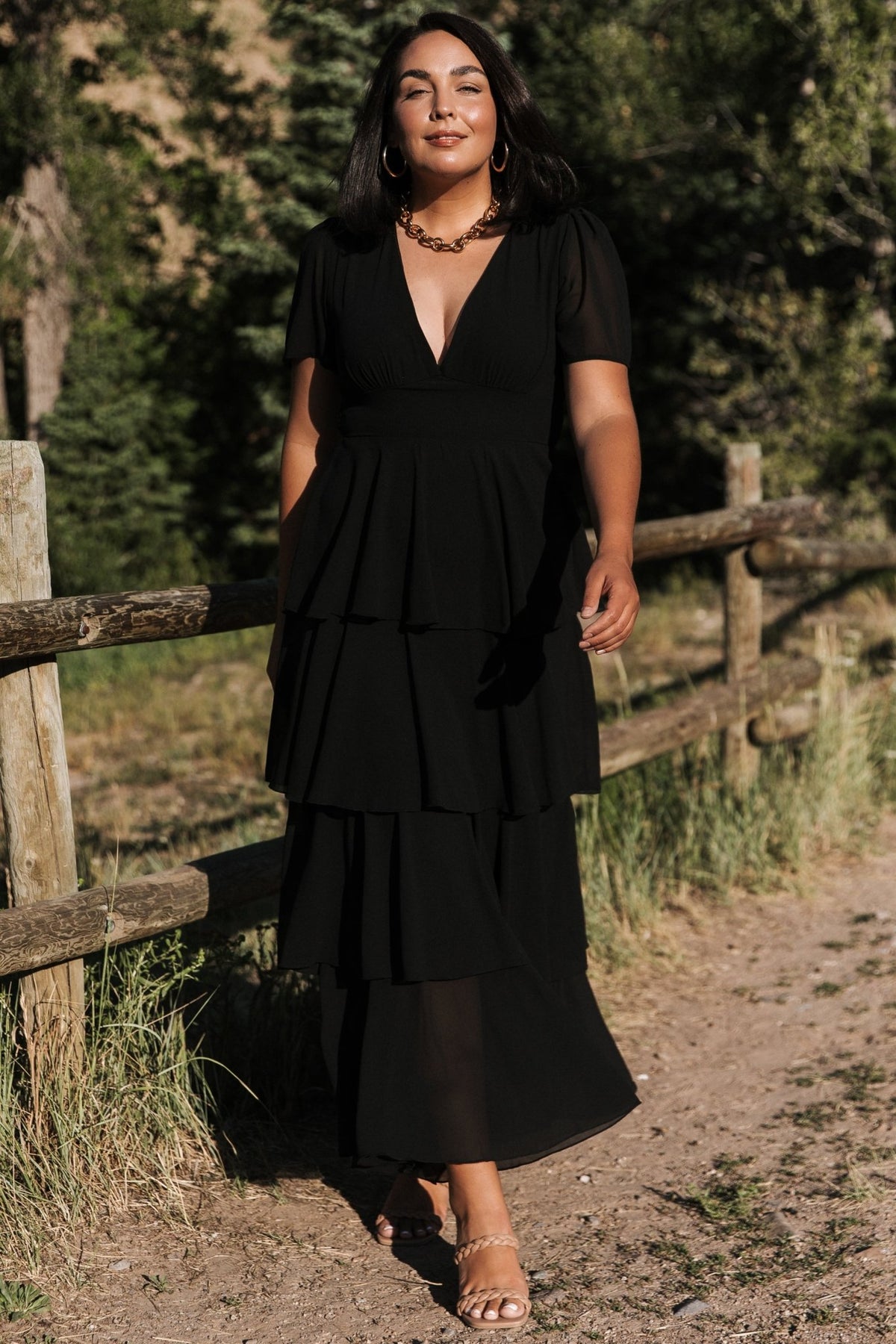 Back view of the black Montaigne ruffle maxi dress showing the smocked back and gentle gathering at the waist for flexible fit.