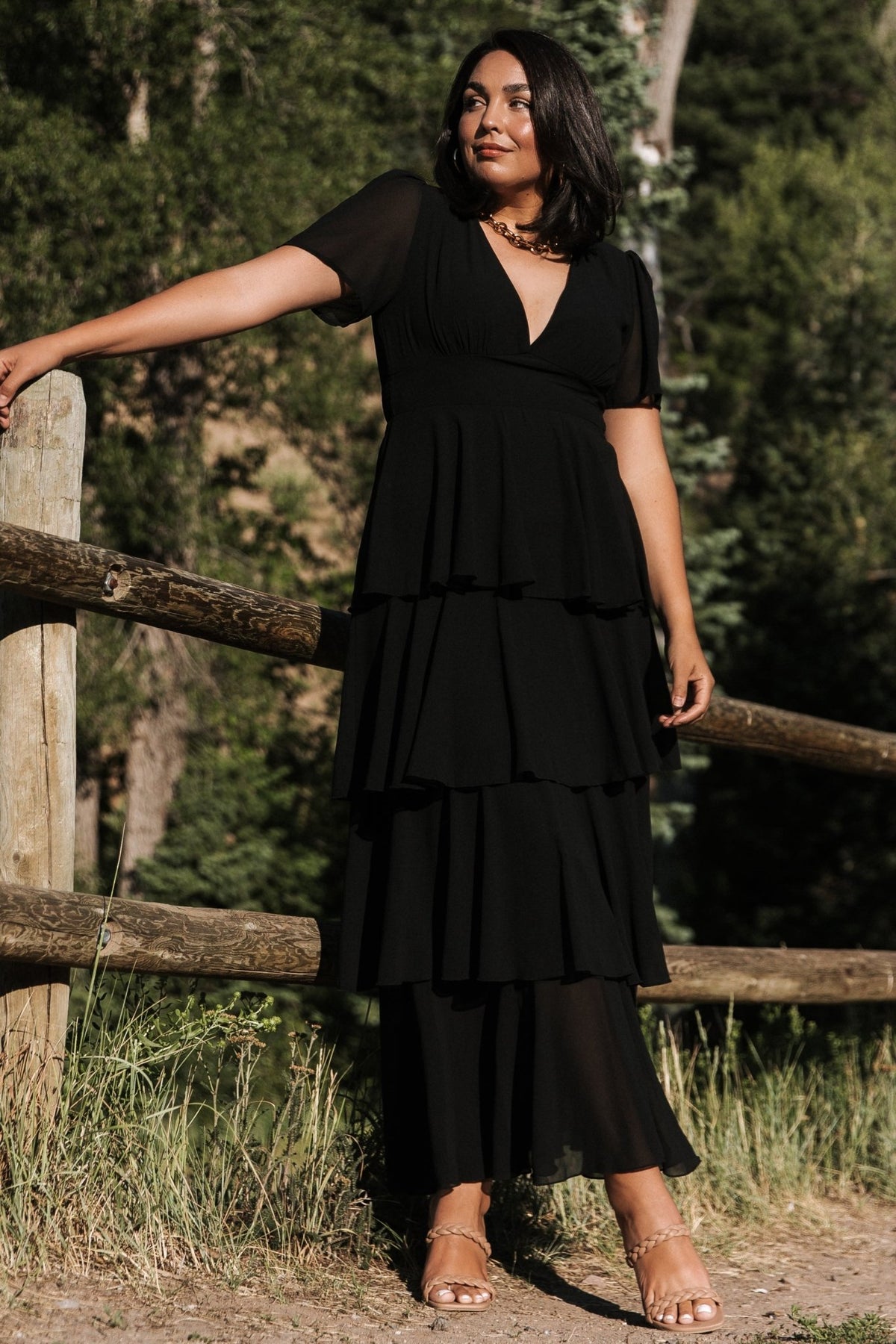 Detail shot of skirt ruffles and lining edge on the black Montaigne dress showing the layered chiffon construction and movement.