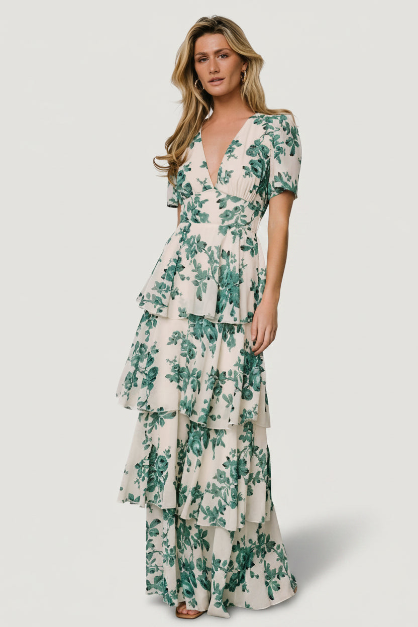 Side view of ivory maxi dress showing layered ruffles, contoured underbust panel, and soft chiffon drape on model.