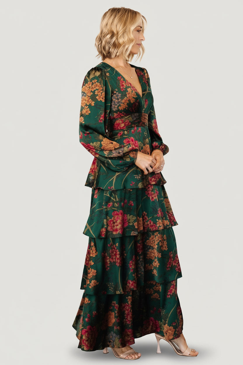 Close-up of emerald floral print on satin fabric showing copper and rose floral details and smooth, lustrous texture.