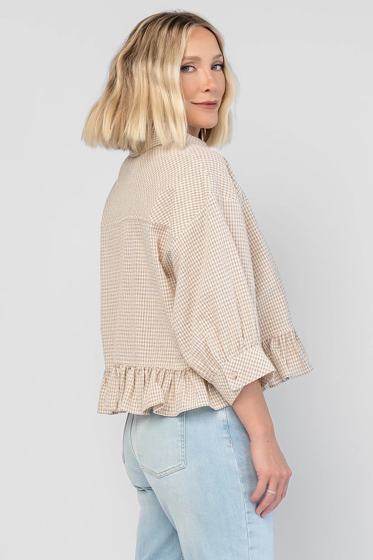 Murphy Relaxed Peplum Top in Beige with a collared neckline, button-front closure, chest pocket, and peplum hem.