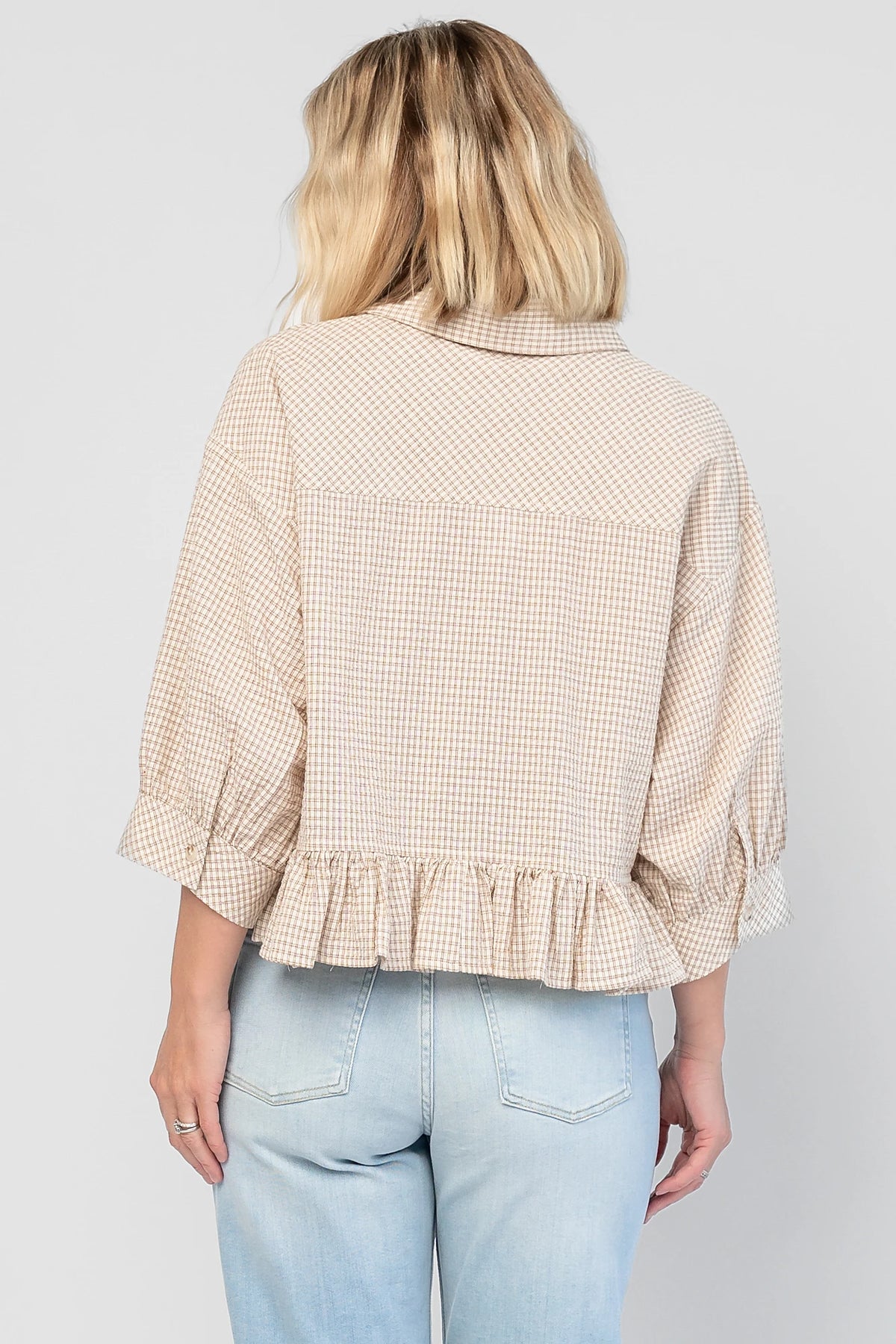 Murphy Relaxed Peplum Top in Beige with a collared neckline, button-front closure, chest pocket, and peplum hem.
