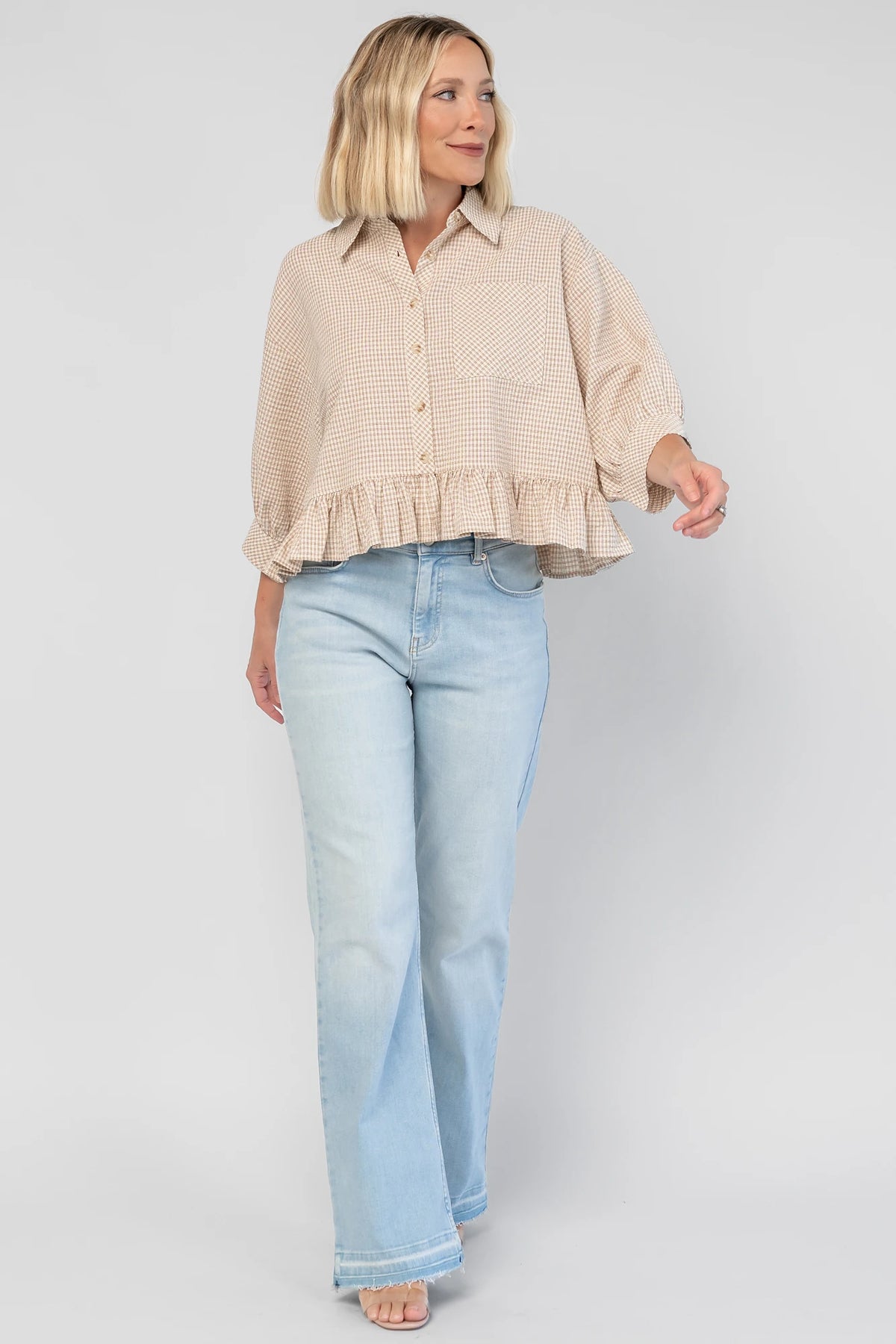 Murphy Relaxed Peplum Top in Beige with a collared neckline, button-front closure, chest pocket, and peplum hem.