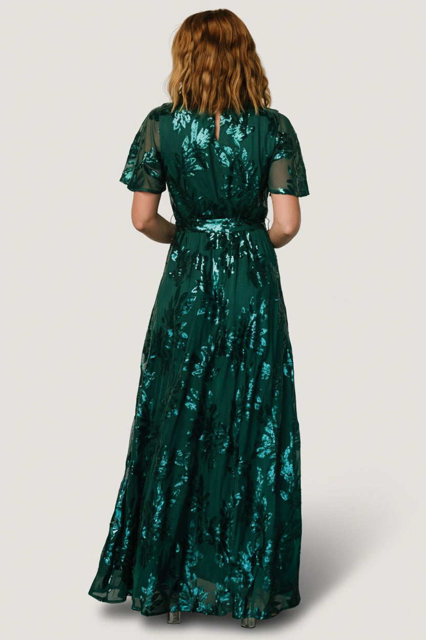 Close-up of sequin leaf detailing on the Muse Sequin Maxi Dress in emerald, showing texture, stitchwork, and subtle iridescence of the sequins.