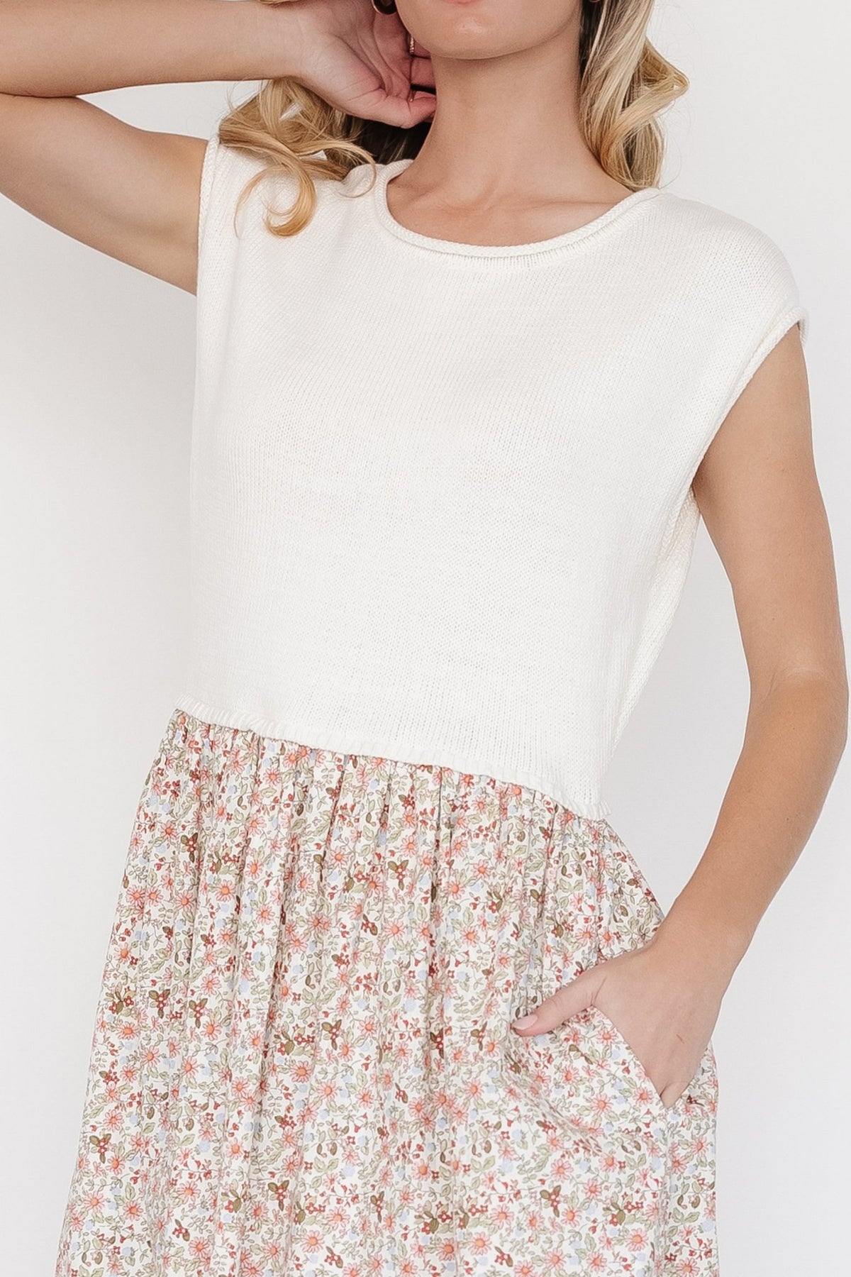 Close-up of sweater-knit bodice and rolled cuff on short cap sleeve, ivory knit contrasted with floral skirt fabric.