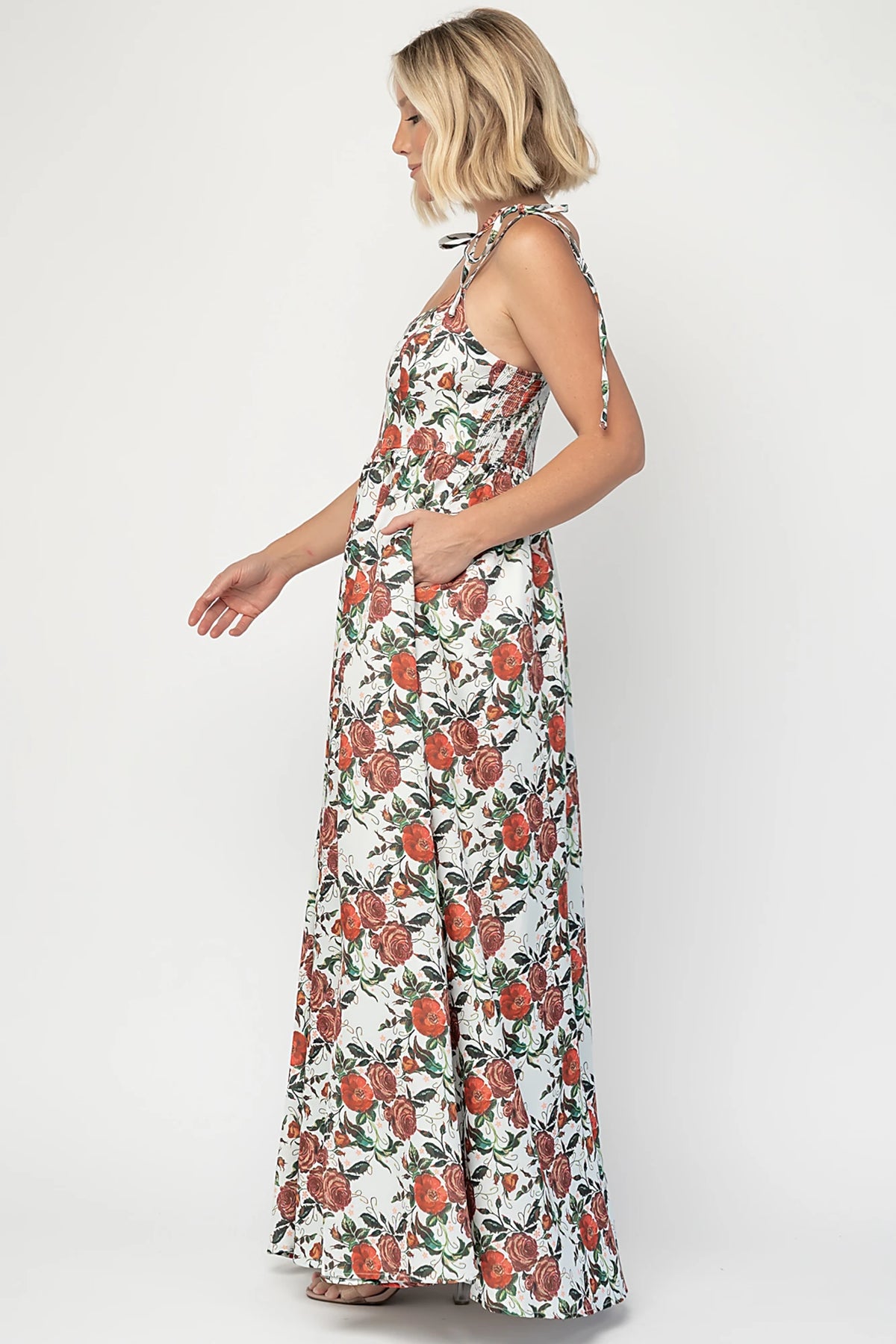 Nadine Maxi Dress in Red + Green Floral with tie straps, smocked back, flowing skirt, and left leg slit.