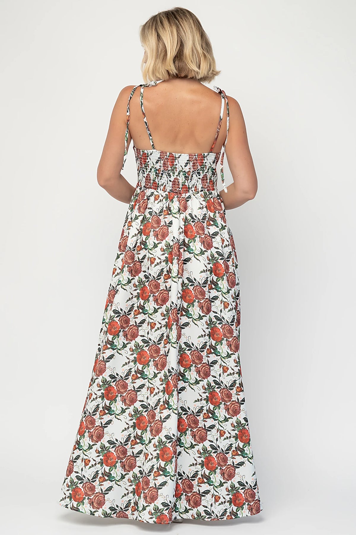 Nadine Maxi Dress in Red + Green Floral with tie straps, smocked back, flowing skirt, and left leg slit.