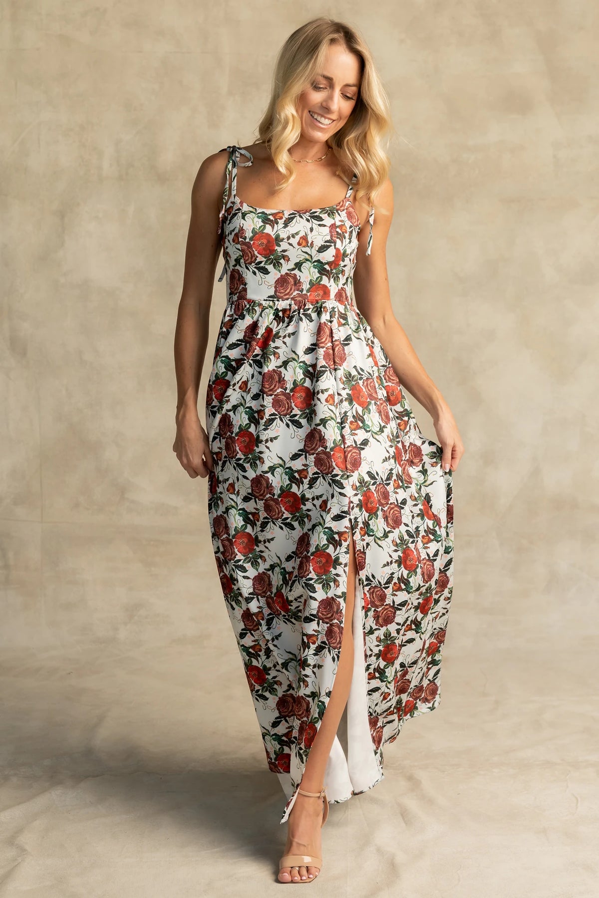 Nadine Maxi Dress in Red + Green Floral with tie straps, smocked back, flowing skirt, and left leg slit.