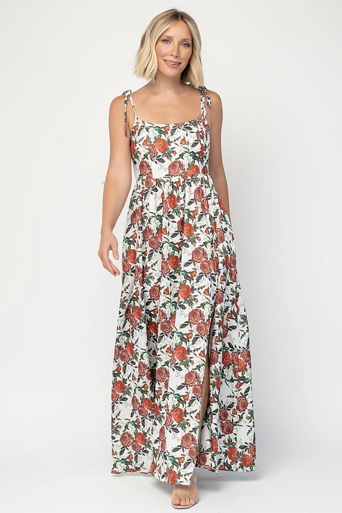 Nadine Maxi Dress in Red + Green Floral with tie straps, smocked back, flowing skirt, and left leg slit.