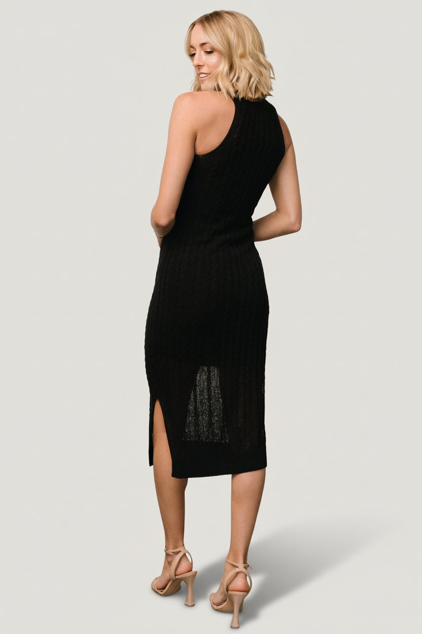 Side view focusing on the sheath silhouette and left-side slit of the Nalani Knit Tank Dress in classic black, knee lining visible.