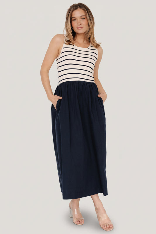 Front view of navy stripe tank dress on model showing sweater-knit bodice, scoop neckline, elastic waist and midi skirt with hidden pockets.