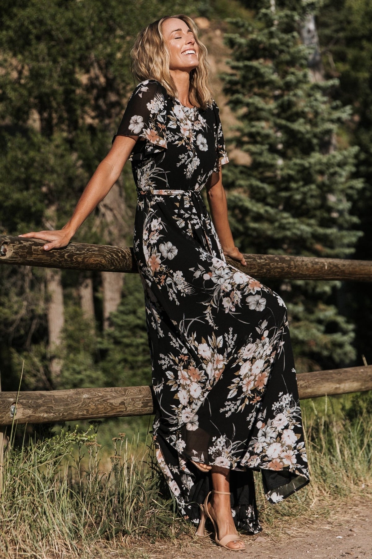 Back view of black floral maxi dress highlighting the keyhole-and-button closure at the nape and elastic back waist.