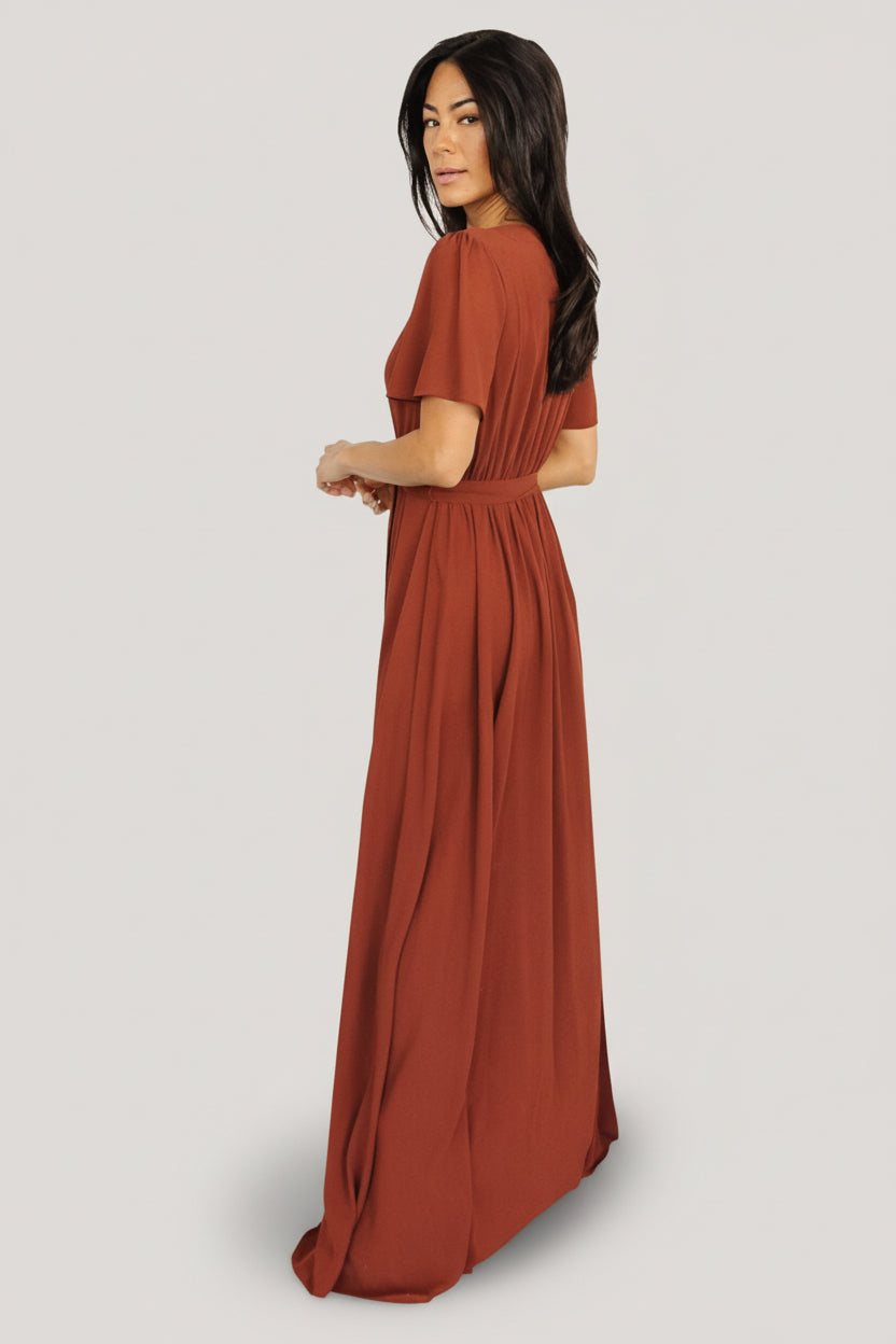 Detail view of the removable belt tie and natural waistline on the Naomi cinnamon chiffon maxi dress.