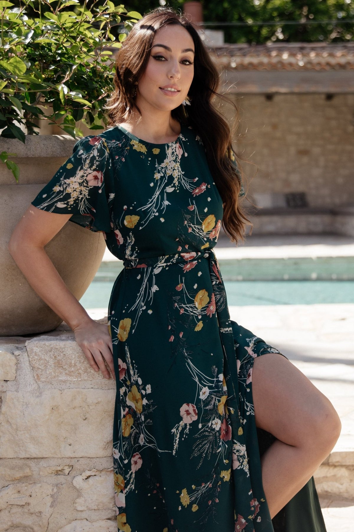 Detail of removable belt tie at the natural waist and elastic back waist on the dark green floral chiffon dress.