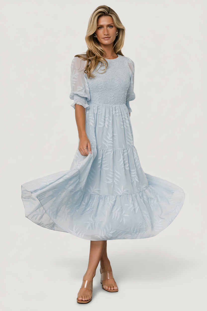 Front view of Nellie Smocked Midi Dress in light blue chiffon with burnout botanical print, showing smocked bodice and puffed poet sleeves.
