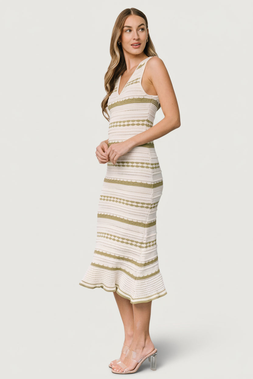 Detail shot of the dress hemline with delicate ruffle in cream and sage pointelle knit, highlighting finishing and texture.