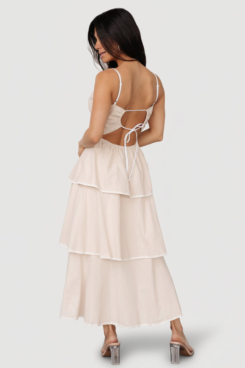 Detail of overlapping midi tiers showing soft volume and movement in the natural linen-blend fabric.