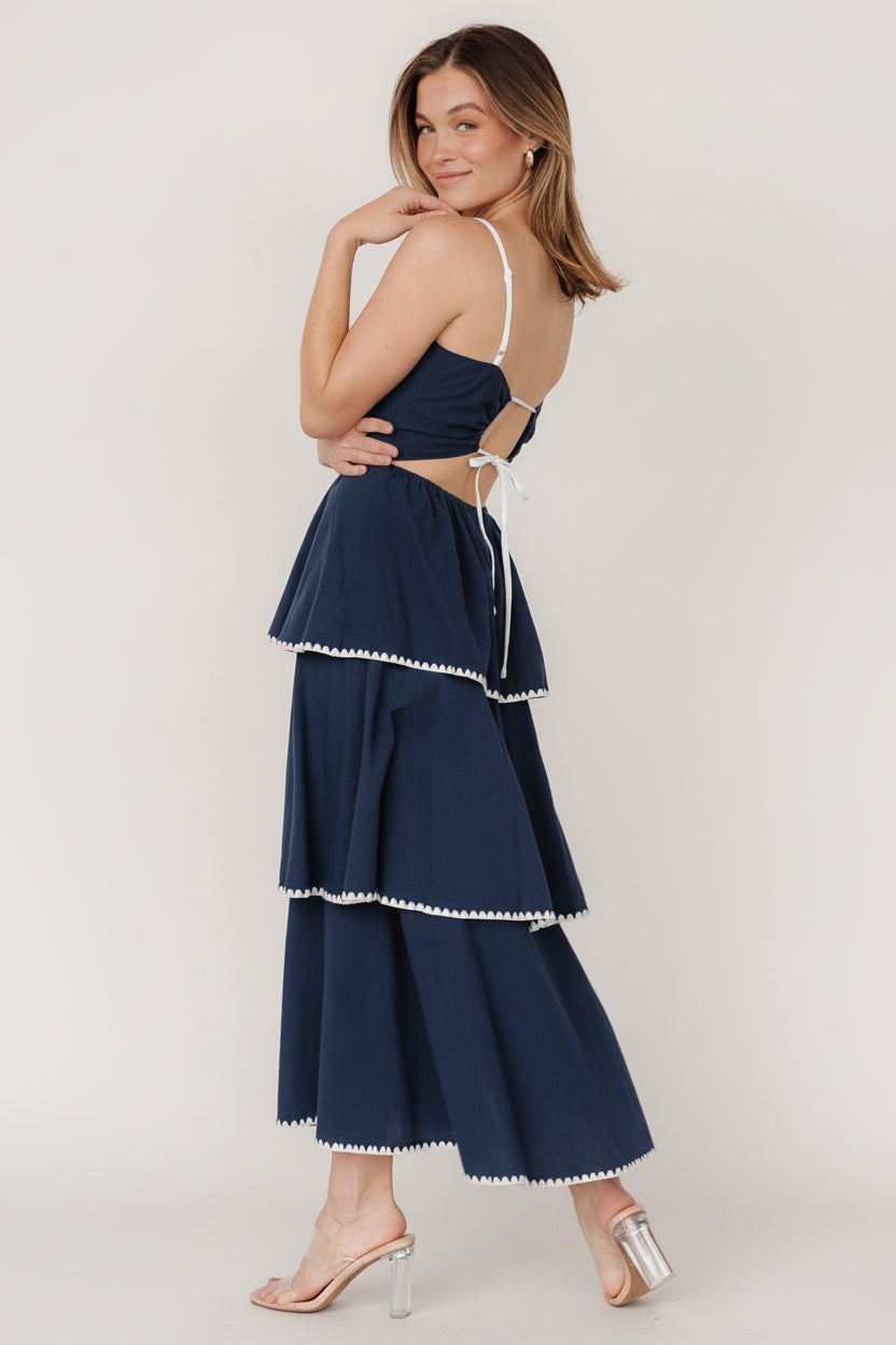 Model wearing Odette midi dress in navy and white walking to show skirt movement and the airy tiered silhouette.